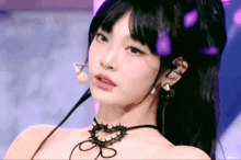 a close up of a woman 's face with a choker and earrings