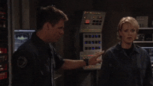 a man and a woman are standing in front of a control panel that says ' s.p.d. ' on it