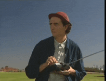 a man in a hat is holding a remote control in his hand