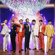 a group of men in suits are standing on a stage holding microphones