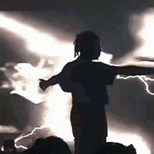 a silhouette of a person in front of a lightning storm