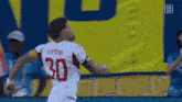 a soccer player wearing a white jersey with the number 30 on the back