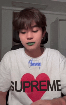 a person wearing a supreme shirt with a heart on it