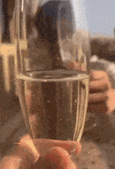 a woman is holding a glass of champagne in her hand