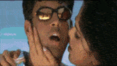 a woman is kissing a man on the cheek and the words ey krishnan are visible in the corner