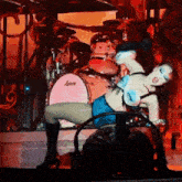 a woman is dancing on stage in front of a ludwig drum