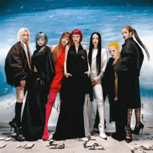 a group of women standing next to each other with one wearing a jacket that says adidas