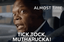 a man in a suit is driving a car and says `` tick tock , muthafucka ! ''