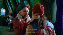 a man in a turban talks to another man in a red hat