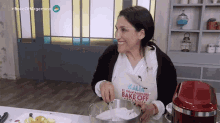 a woman is wearing an apron that says bake off on it
