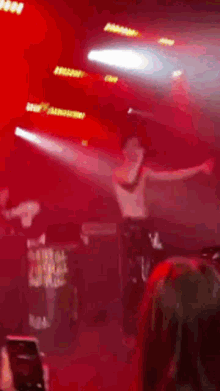 a man without a shirt is dancing on a stage with his arms outstretched