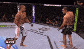 two men are fighting in a cage with metropcs and musclepharm signs
