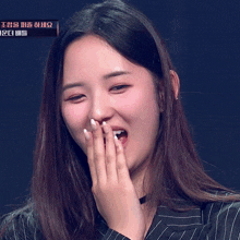 a woman covering her face with her hands while holding a microphone