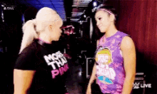 a couple of women are standing next to each other and one of them is wearing a shirt that says more than pink .