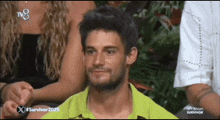 a man in a green shirt is sitting in front of a tv screen that says survivor 2025