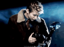 a man in a suit and tie is holding a camera in his hand in a dark room .