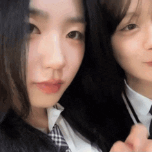 two girls in school uniforms are posing for a photo