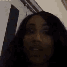 a close up of a woman 's face in a dark room with a door in the background .