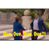 a man in a blue suit and a woman in a red dress are walking down stairs .