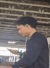 a man wearing earbuds looks at his phone