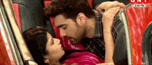 a man and a woman are kissing in a red car with 2:30 pm written on the bottom