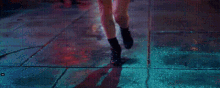 a woman in a red dress is walking down a street in a dark room .
