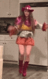 a woman in a pink cowboy hat is dancing in the kitchen