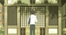 a man in a white shirt is standing in front of a building with squares on it