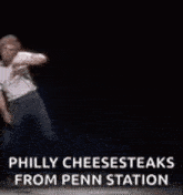 a man is dancing on a stage in front of a black background .