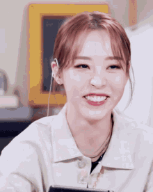 a close up of a woman 's face with a smile on her face and a yellow frame in the background