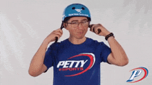 a man wearing a blue shirt that says petty sports