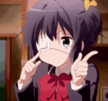 a girl with a bandage on her eye is making a funny face .