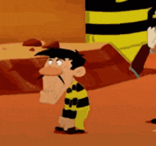 a cartoon character with a mustache and a yellow and black striped shirt is standing in the desert .