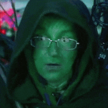 a person with green paint on their face is wearing glasses