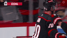 a hockey player with the number 20 on his jersey is celebrating a goal