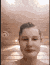 a blurred image of a person 's face with a ceiling fan in the background
