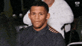 a man in a black shirt sits in front of a screen that says ufc