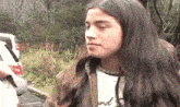 a woman with long hair is wearing a white shirt that says " and " on it