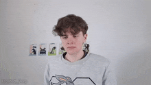 a man is standing in front of a wall with pictures of animals on it