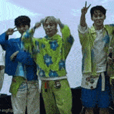 a group of young men are standing next to each other making peace signs