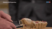 a close up of a person cutting a piece of cake with the words masterchef argentina on the bottom left