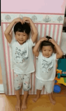 a boy and a girl are standing next to each other in a room .