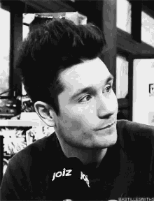 a black and white photo of a man wearing a joiz shirt .