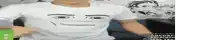 a man is wearing a white t-shirt with a face drawn on it .