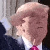 a close up of a man in a suit and tie saluting .