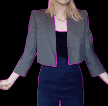 a woman wearing a gray jacket and a blue skirt has her arms outstretched