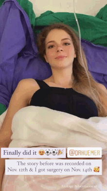 a woman in a black top is laying in a hospital bed with an iv in her arm
