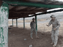 two soldiers are standing under a wooden roof