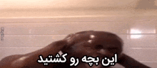 a man is taking a shower in a bathroom with a foreign language .