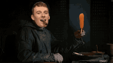 a man smoking a cigar and holding a carrot in his hand